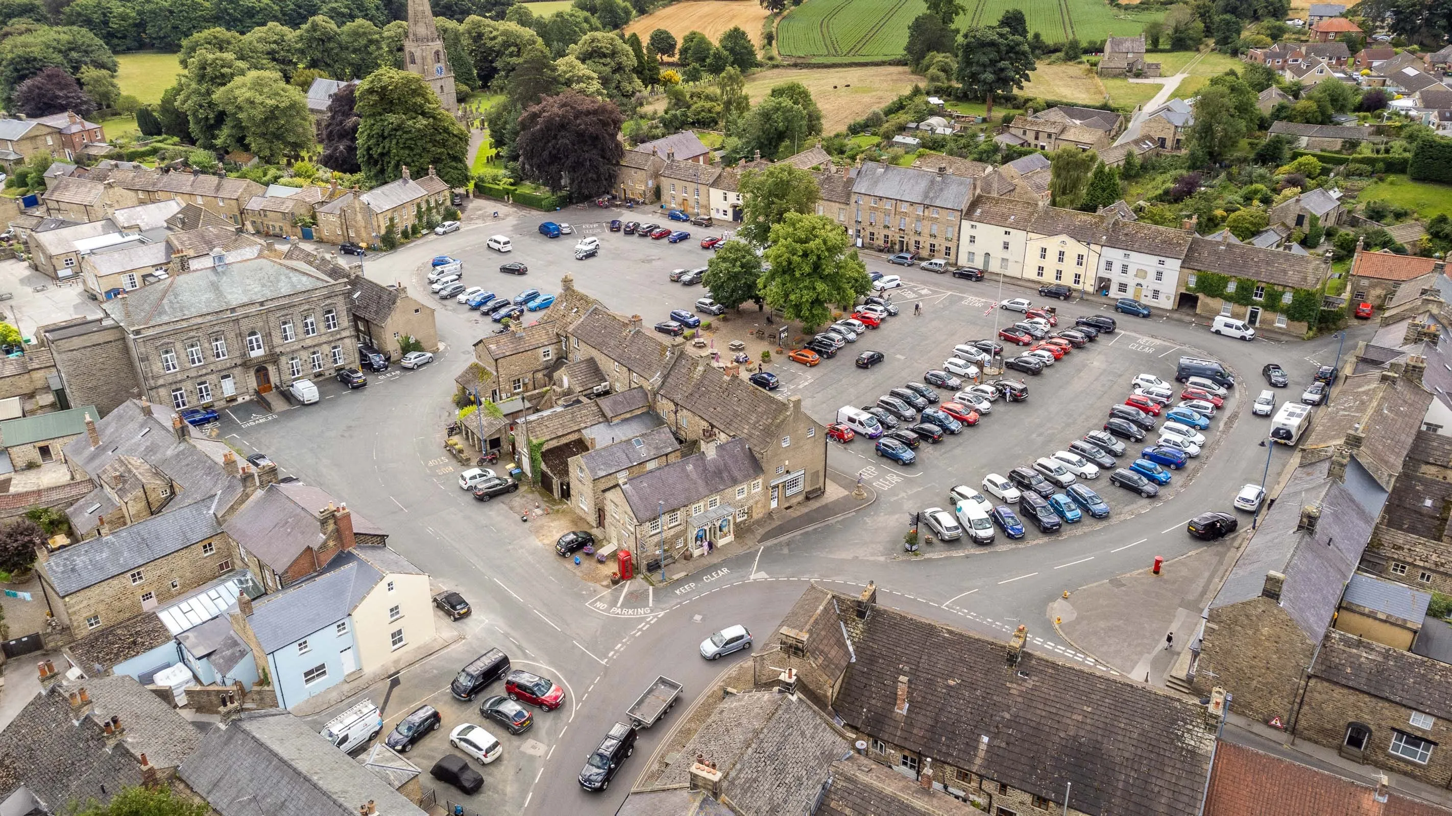 Masham's market place from above, with the church spire and open farmland behind