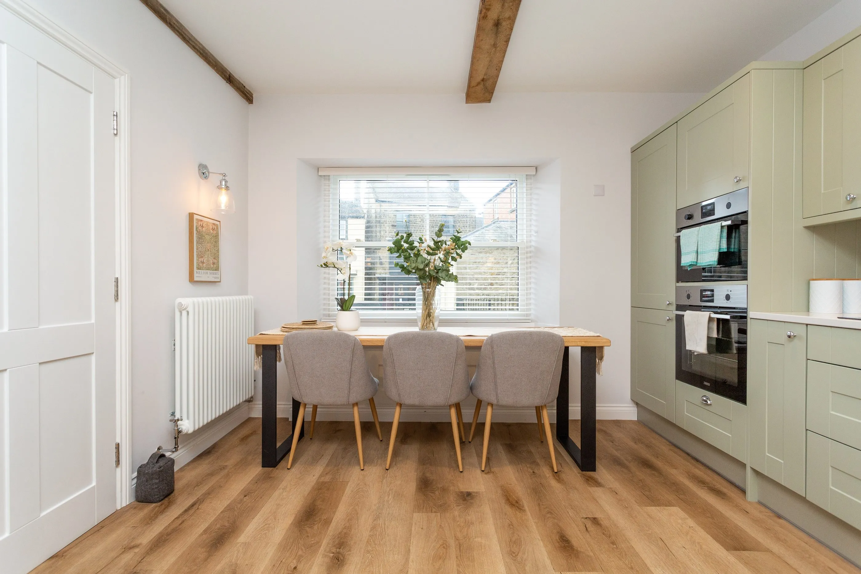 Dining table for six beneath the window, beside the kitchen