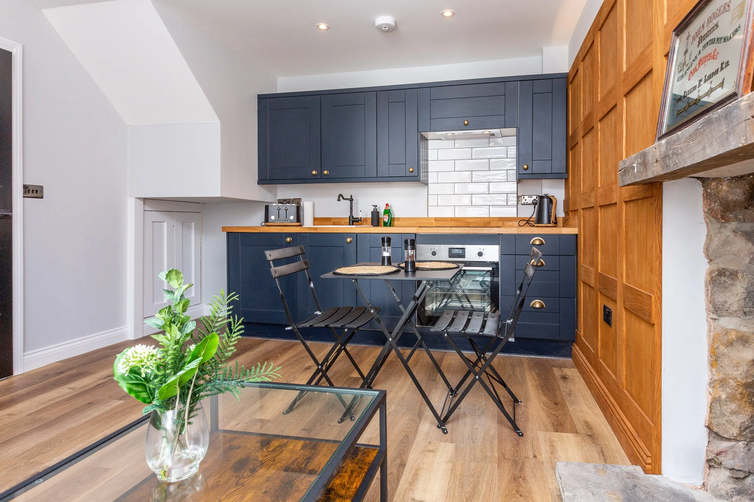 Navy shaker kitchen with oak worktops and a bistro table for two