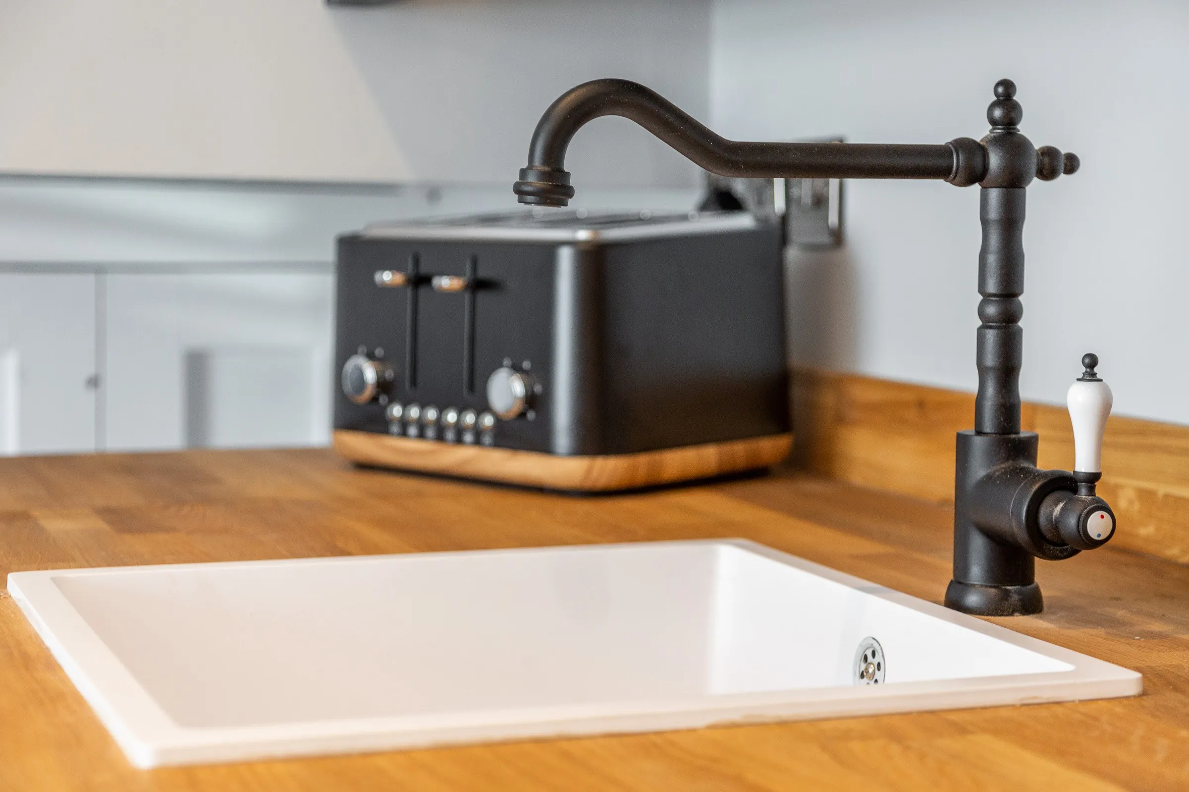 Traditional black kitchen tap on an oak worktop