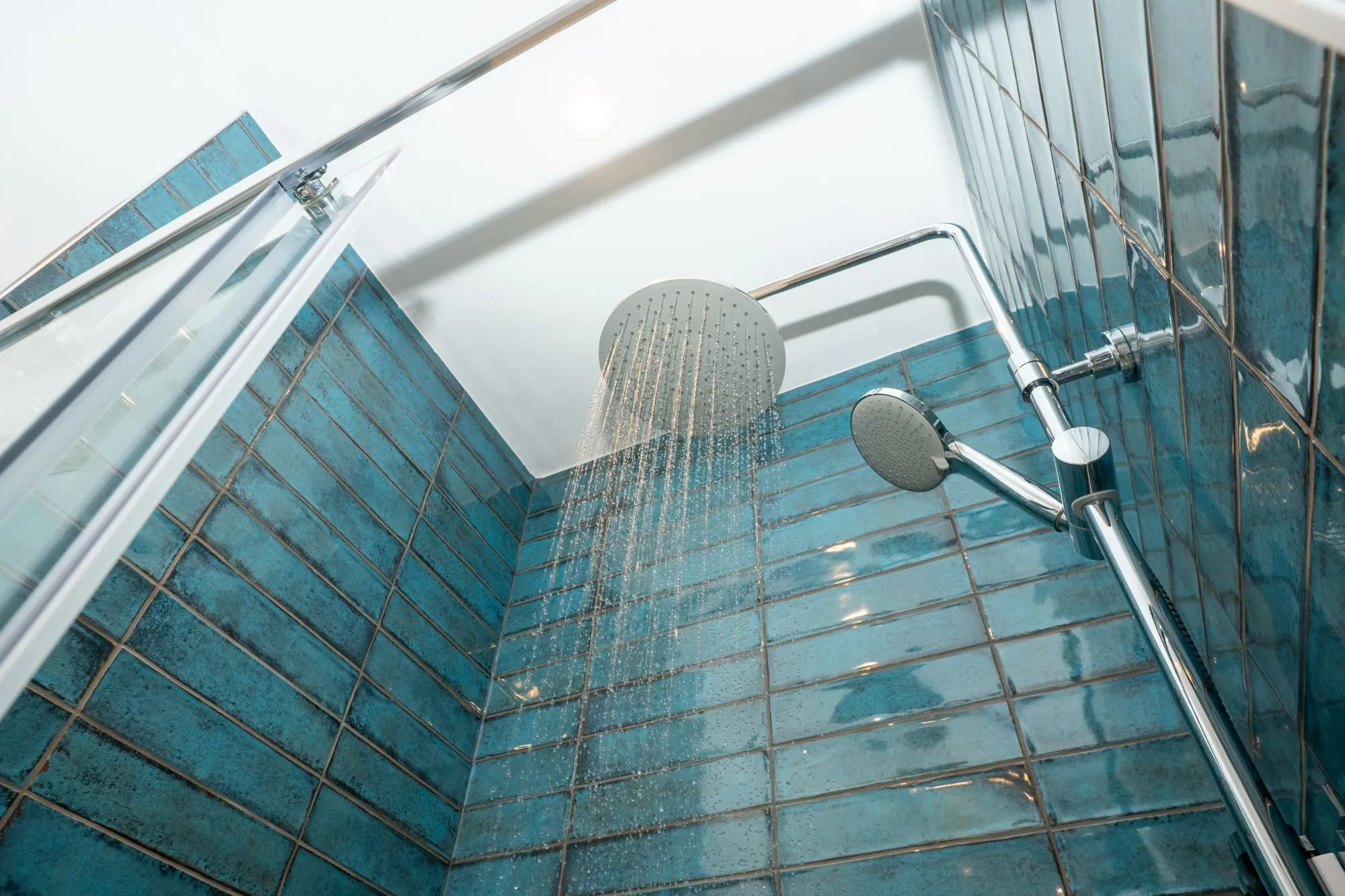 Looking up into a rain shower lined with blue glazed tiles