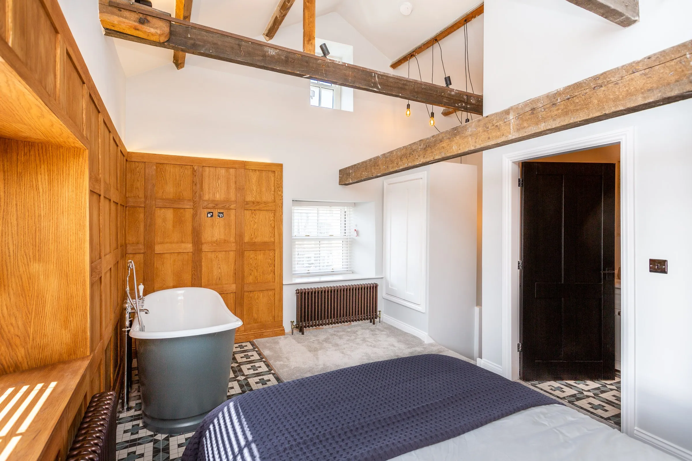 Bedroom with exposed beams, roll-top bath and window seat