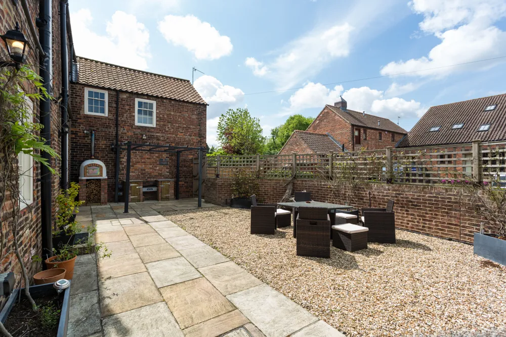 Sunny gravel courtyard with outdoor dining set